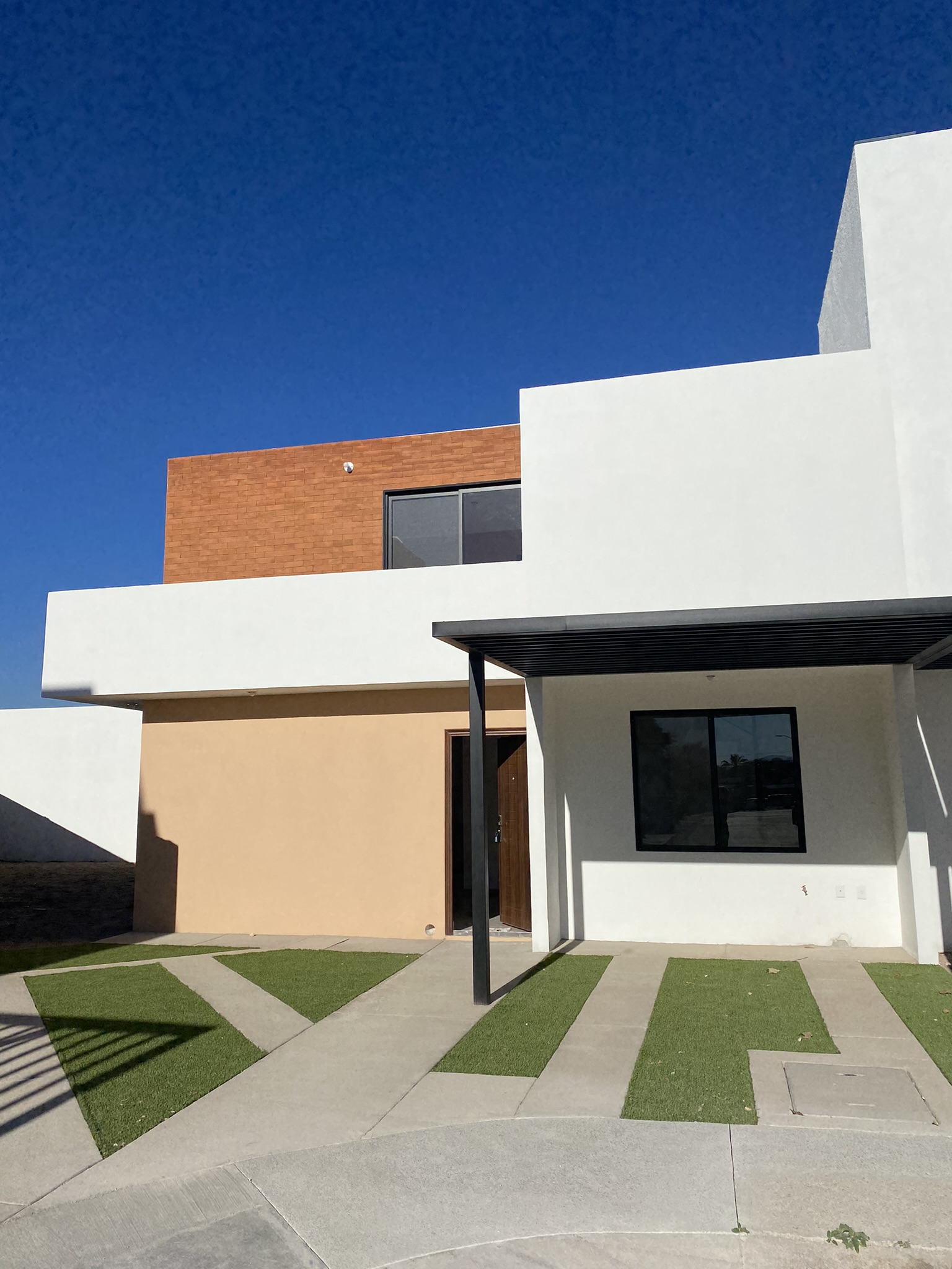 10 Fachada frontal de la casa modelo Amada en Fraccionamiento Antequera, Pozos, San Luis Potosí, con jardín y entrada principal.