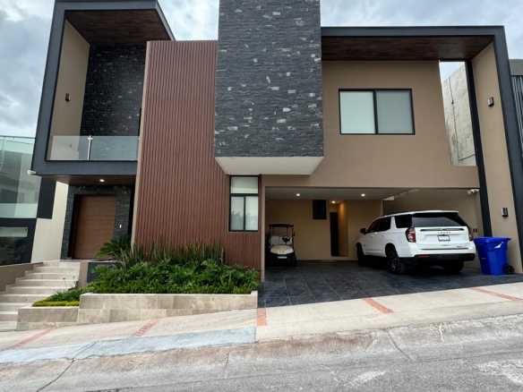 Fachada moderna de casa en La Loma Residential & Golf Club con vistas a la ciudad y jardín iluminado.