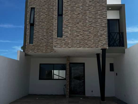 Fachada de casa de 3 niveles en Residencial Encino, Pozos SLP; cochera para 2 autos, jardín y roof garden con asador.
