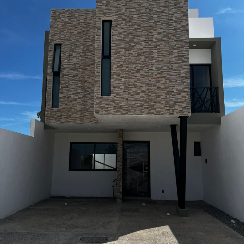 Fachada de casa de 3 niveles en Residencial Encino, Pozos SLP; cochera para 2 autos, jardín y roof garden con asador.