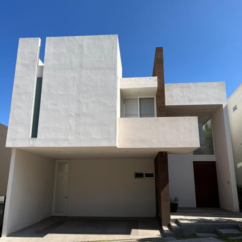 Fachada moderna de casa en venta en fraccionamiento Sierra Azul, San Luis Potosí, con cochera para 2 autos.