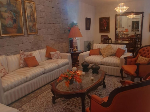 Fachada moderna y estancia a doble altura con acabados de piedra en Punta San Luis, SLP.