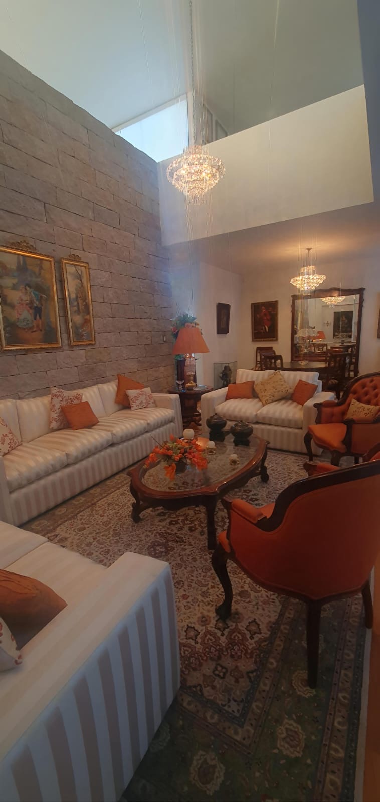 Fachada moderna y estancia a doble altura con acabados de piedra en Punta San Luis, SLP.