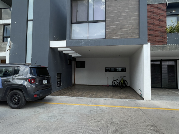 Casa moderna de tres niveles con fachada gris y acabados tipo madera en Cimera Residencial, Mexquitic de Carmona, SLP.