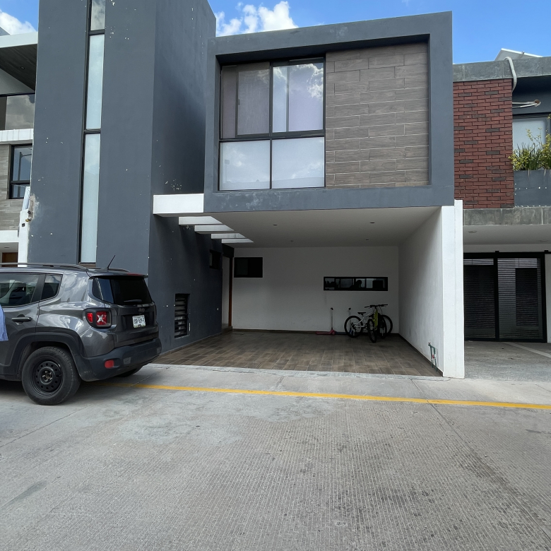 Casa moderna de tres niveles con fachada gris y acabados tipo madera en Cimera Residencial, Mexquitic de Carmona, SLP.