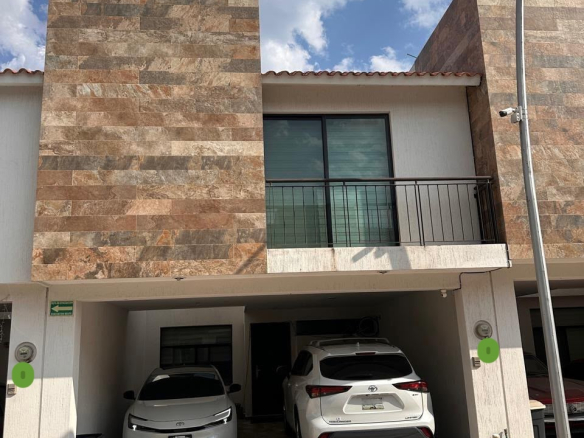 Casa en venta en Privada Amanecer, Alborada Residencial, SLP - Fachada con cochera techada para 2 autos y acabados de recubrimiento cerámico tipo piedra.