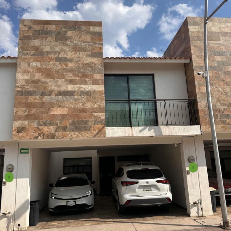 Casa en venta en Privada Amanecer, Alborada Residencial, SLP - Fachada con cochera techada para 2 autos y acabados de recubrimiento cerámico tipo piedra.